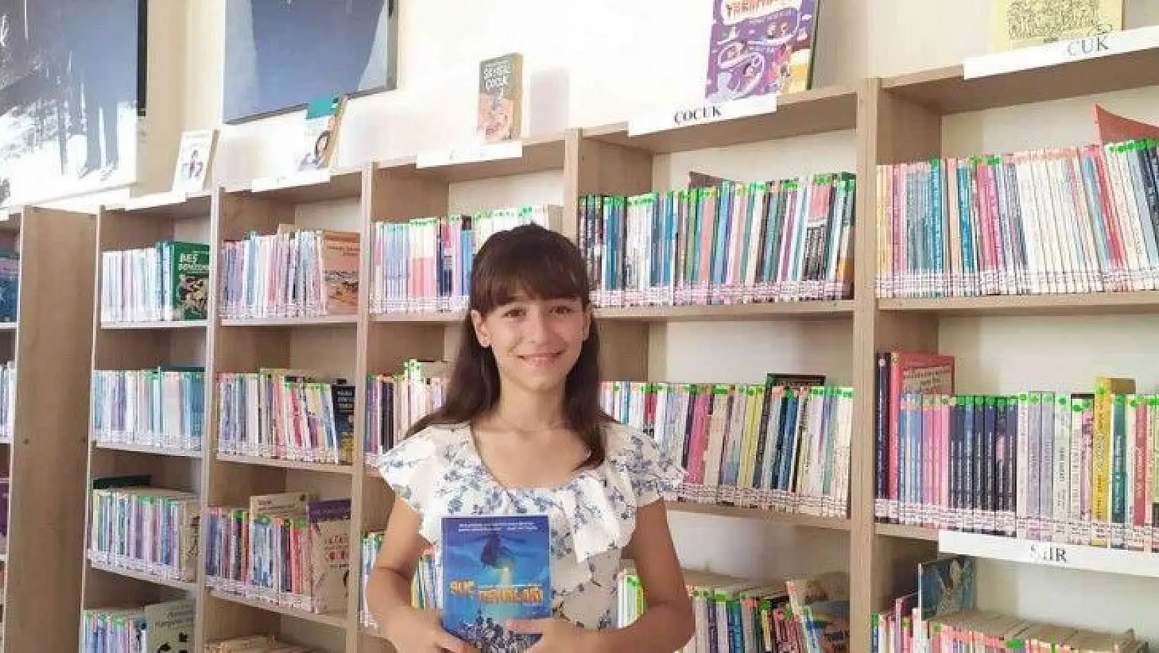 Kitap kurdu minik Elif kütüphanede gönüllü çalışıyor