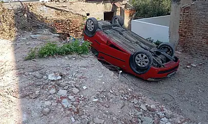 Erdek'te park etmeye çalışırken takla atan araç arsaya düştü